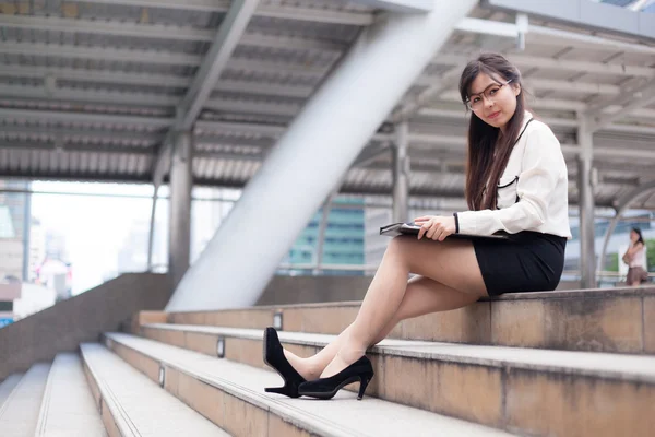 Happy affärskvinna sitter på trottoaren. — Stockfoto