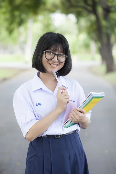 Schoolgirl standing holding a book. — Stock Photo, Image