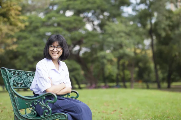 Fille sourire et assis sur le banc . — Photo