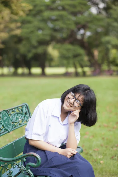 女孩的笑容，坐在板凳上. — 图库照片