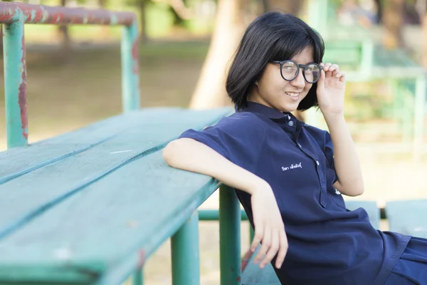 Chica con gafas sentada en el banco . —  Fotos de Stock