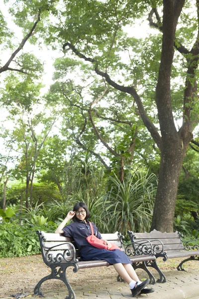 Girl wearing glasses sitting on the bench. — Stock Photo, Image