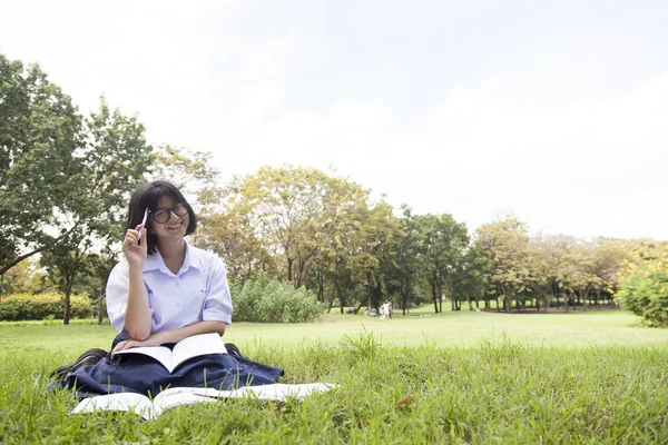 女子高生が芝生の上に読んでいた. — ストック写真