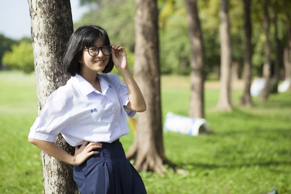 Fille debout et souriant près d'un arbre . — Photo