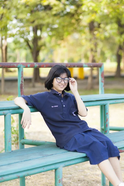 Mädchen mit Brille sitzt auf der Bank. — Stockfoto