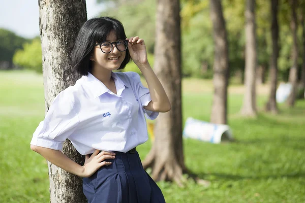 Ragazza in piedi e sorridente vicino a un albero . — Foto Stock