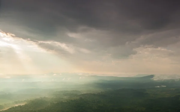 山や森に雲の切れ間から太陽の光輝く — ストック写真