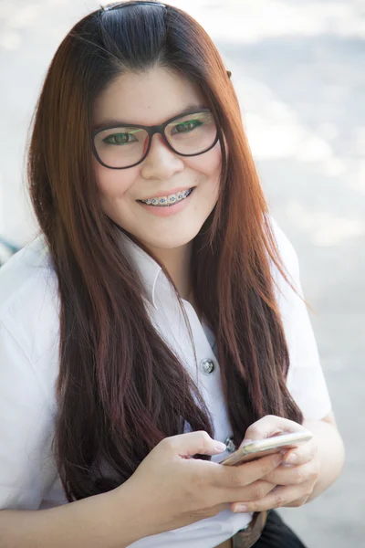 Mujer con gafas está sentado en un teléfono inteligente . — Foto de Stock