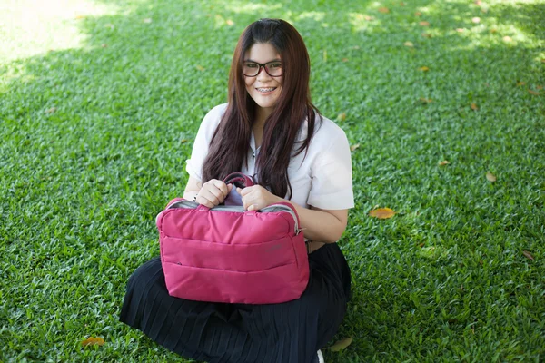 Estudante feminina sentada no gramado . — Fotografia de Stock