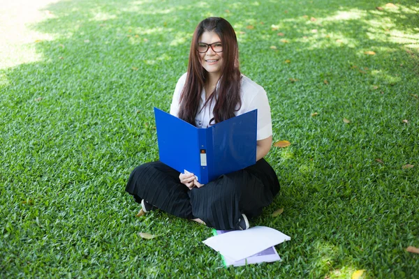 Female student sitting on the lawn — Stock Photo, Image