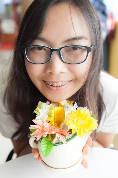 Asya kadın tutun pot çiçek. — Stok fotoğraf