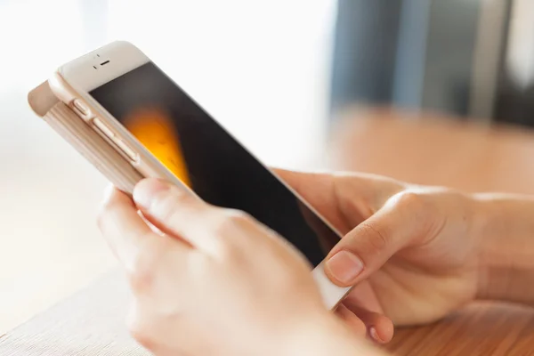 Hand está jugando un teléfono inteligente . — Foto de Stock