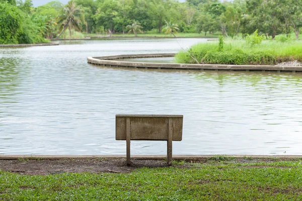 Banco de pedra na grama — Fotografia de Stock