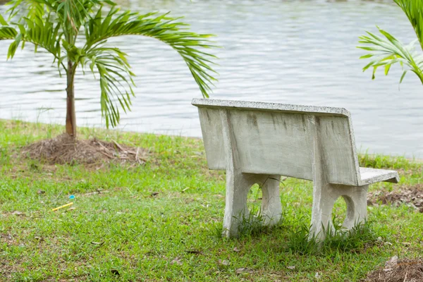 Каменная скамейка в траве — стоковое фото
