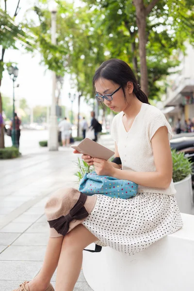 Frau sitzt und nutzt Smartphone. — Stockfoto