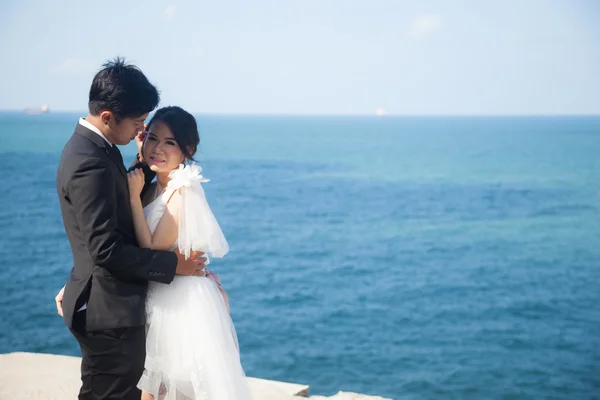 Noiva e noivo em pé junto ao mar . — Fotografia de Stock