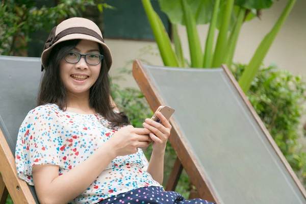 Frau auf der Couch und Smartphone spielen. — Stockfoto