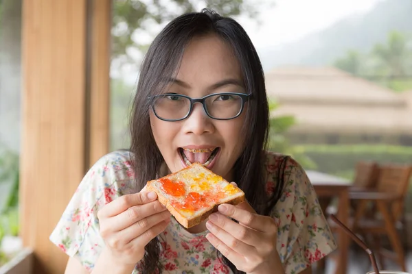 Жінка їсть хліб з джемом Ліцензійні Стокові Зображення