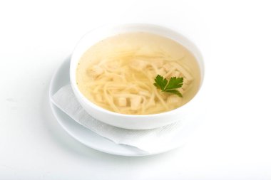 Beyaz tabakta ev yapımı erişteli tavuk suyu çorbası.