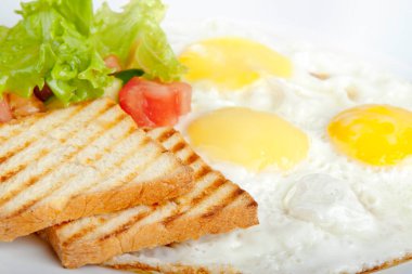 Kızarmış yumurtalı tost ve salatalık salatası ve otlu domates.