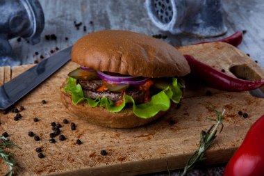 Tahtada hamburger, bıçakla ve biberle öğütücü
