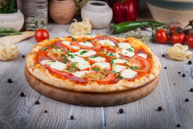 Dekoratif tasarımlı, tahta ışıklı arka planda bir pizza.