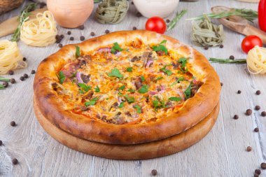 Dekoratif tasarımlı, tahta ışıklı arka planda bir pizza.