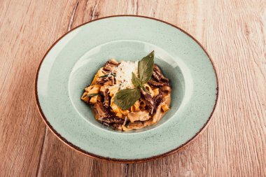 Ahşap arka planda et soslu İtalyan makarnası.