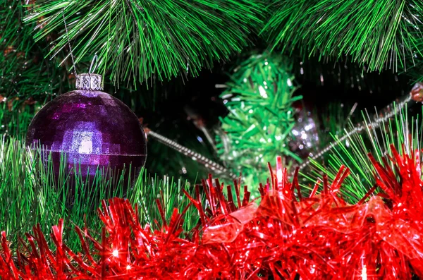 Shabby ball and tinsel on artificial Christmas tree — Stock Photo, Image