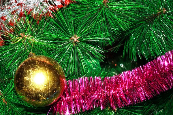 Shabby ball and tinsel on artificial Christmas tree — Stock Photo, Image