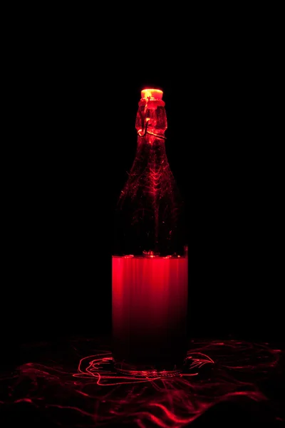 Glass bottle with sparks and waves of light — Stock Photo, Image