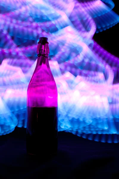 Bottiglia di vetro con scintille e onde di luce — Foto Stock