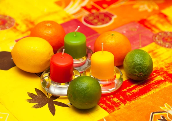 Citron, lime et mandarine sur la table avec des bougies. Jaune, vert, orange — Photo