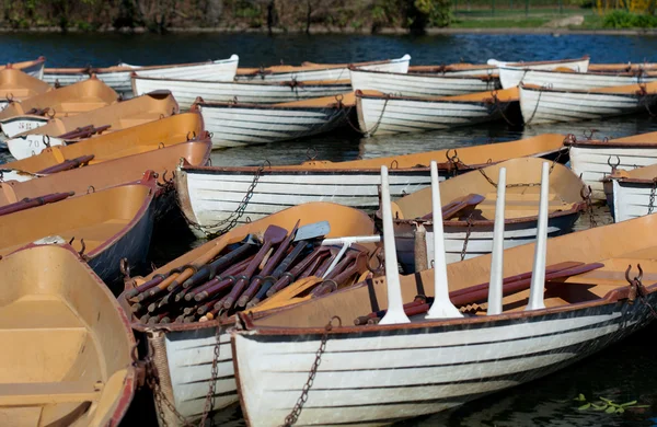 Boats with oars on blue water in park at springtime — Stock Photo, Image