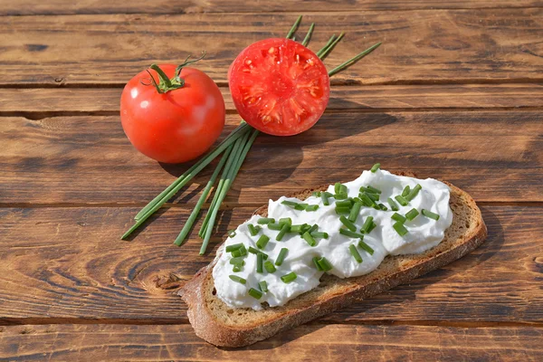Bröd med tomat och keso på träbord — Stockfoto