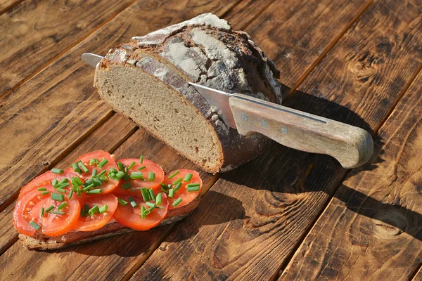 Bread with knife and tomatoes — Stock Photo, Image