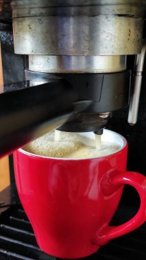 Kırmızı bardaklı espresso makinesi.