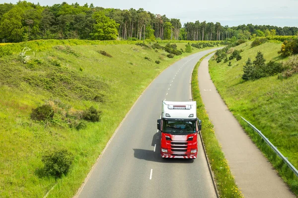 red lorry truck on uk motorway road in england.