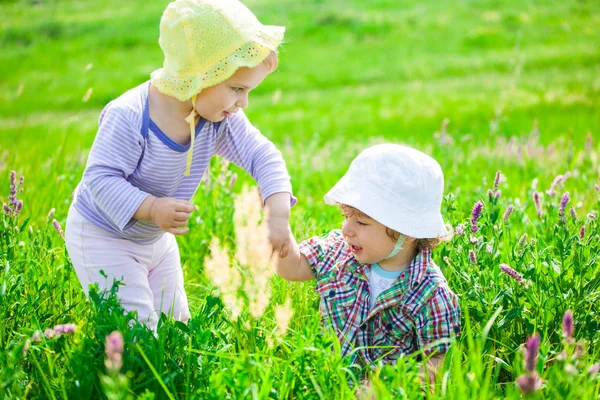 Bébé garçon et bébé fille sur une prairie — Photo