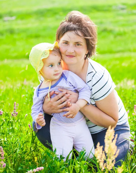 Bir çayır üzerinde anne ile kız bebek — Stok fotoğraf