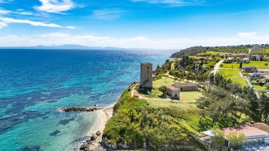 View of the Byzantine Tower of Saint Paul in Nea Fokaia, Chalkidiki, Greece, near the coast with turquoise sea and village landscape.