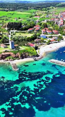 Drone view of Nea Fokaia in Chalkidiki, Greece, showing turquoise water, the harbour, fishing boats, and coastline under summer light.