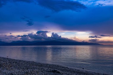 Yunanistan 'ın orta kesimindeki Korint Körfezi üzerinde gün batımı, Skaloma köyünden ele geçirildi. Sahne, altın saat boyunca renkli gökyüzü, sakin deniz ve Akdeniz kıyılarını gösteriyor. Yunanistan 'ın deniz manzarası ve seyahat manzarası.