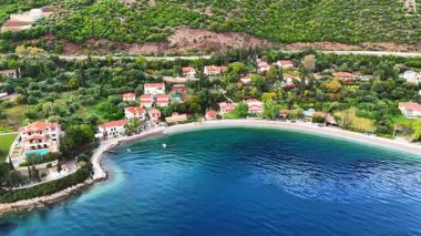 Yunanistan 'ın orta kesimindeki bir kıyı kasabası olan Skaloma' nın hava aracı görüntüsü, Corinth Körfezi kıyı şeridi, açık mavi deniz, geleneksel evler ve Akdeniz manzarasını gösteriyor. Manzaralı Yunan kıyıları, yaz gezileri, yüksek açılı insansız hava aracı görüntüleri.