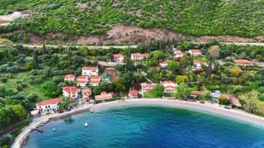 Yunanistan 'ın orta kesimindeki bir kıyı kasabası olan Skaloma' nın hava aracı görüntüsü, Corinth Körfezi kıyı şeridi, açık mavi deniz, geleneksel evler ve Akdeniz manzarasını gösteriyor. Manzaralı Yunan kıyıları, yaz gezileri, yüksek açılı insansız hava aracı görüntüleri.