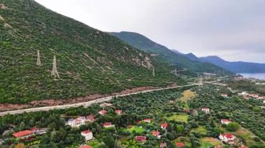 Yunanistan 'ın orta kesimindeki bir kıyı kasabası olan Skaloma' nın hava aracı görüntüsü, Corinth Körfezi kıyı şeridi, açık mavi deniz, geleneksel evler ve Akdeniz manzarasını gösteriyor. Manzaralı Yunan kıyıları, yaz gezileri, yüksek açılı insansız hava aracı görüntüleri.