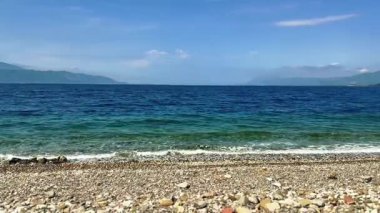 Yunanistan 'ın orta kesimindeki Korint Körfezi' ne bakın. Skaloma köyü ve plajından ele geçirildi. Çakıl taşlı sahilde güneşli bir gün..