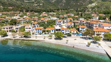 Yunanistan 'daki Delphi Riviera boyunca Corinth Körfezi' ndeki Paralia Sergoulas 'ın insansız hava aracı görüntüsü. Bahar manzarasında turkuaz su, huzurlu bir sahil şeridi ve küçük sahil köyünü çevreleyen taze yeşillik yer alıyor..