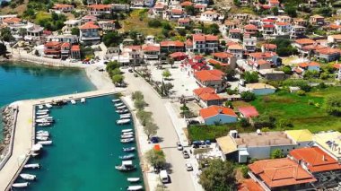 Yunanistan 'ın orta kesimindeki bir kıyı köyü olan Glyfada' nın insansız hava aracı görüntüsü, Korint Körfezi kıyı şeridi, açık mavi deniz, geleneksel evler ve Akdeniz manzarasını gösteriyor. 