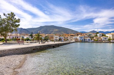 Yunanistan 'ın orta kesimindeki tarihi bir kıyı kasabası olan Galaxidi' nin görüntüsü, baharda çekildi. Geleneksel beyazlatılmış ve taştan evler, renkli detaylar, çiçek açan bitkiler, ve Corinth Körfezi boyunca sakin mavi su. Resimli bir Akdeniz manzarası.